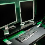 Dual monitor setup in a gaming room with keyboard and mouse